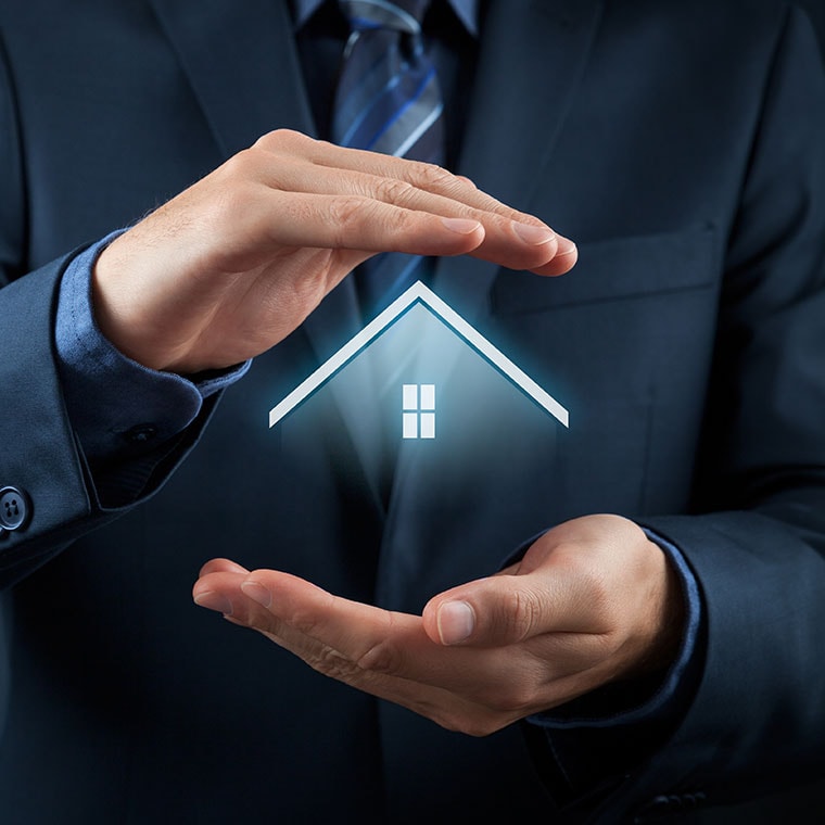 Man holding small model house in his hands to signify protection or investment.